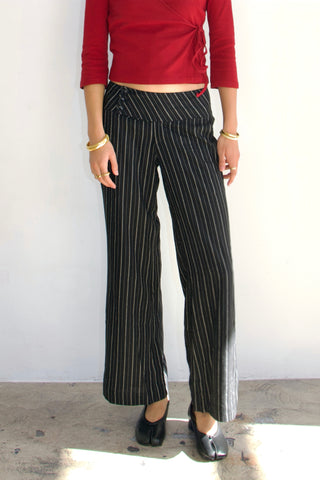 Person wearing a red top and black pinstripe pants against a white background